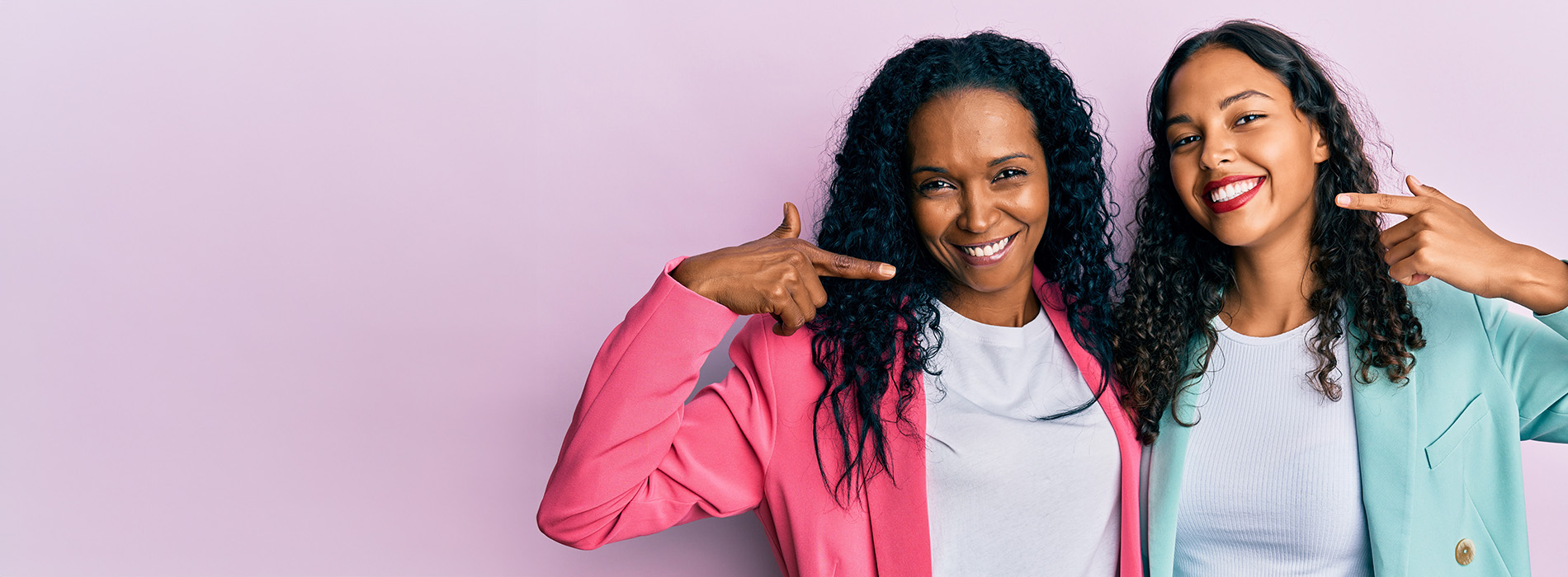 Two individuals posing with thumbs up against a pink background, likely for a promotional or professional purpose.